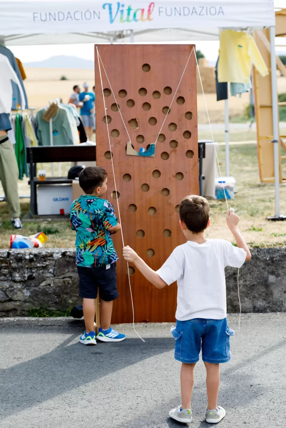 Juegos de madera del festival, con participantes vistos de espaldas